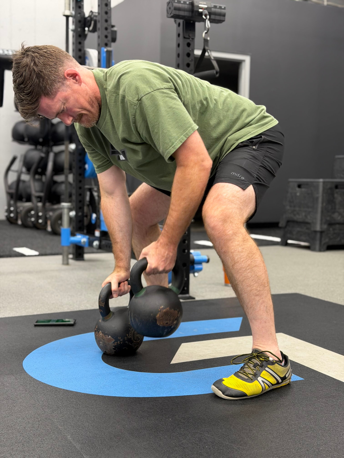 A Vital member performing a kettlebell lift during a coached session